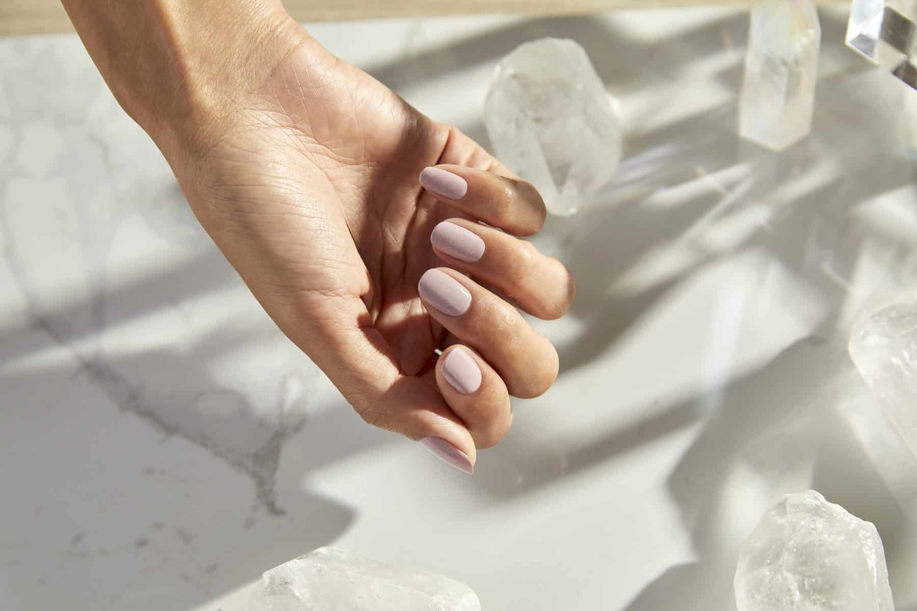 A hand with painted nails in the "Quest for Quartz" shade from the Palette Xbox collection from OPI