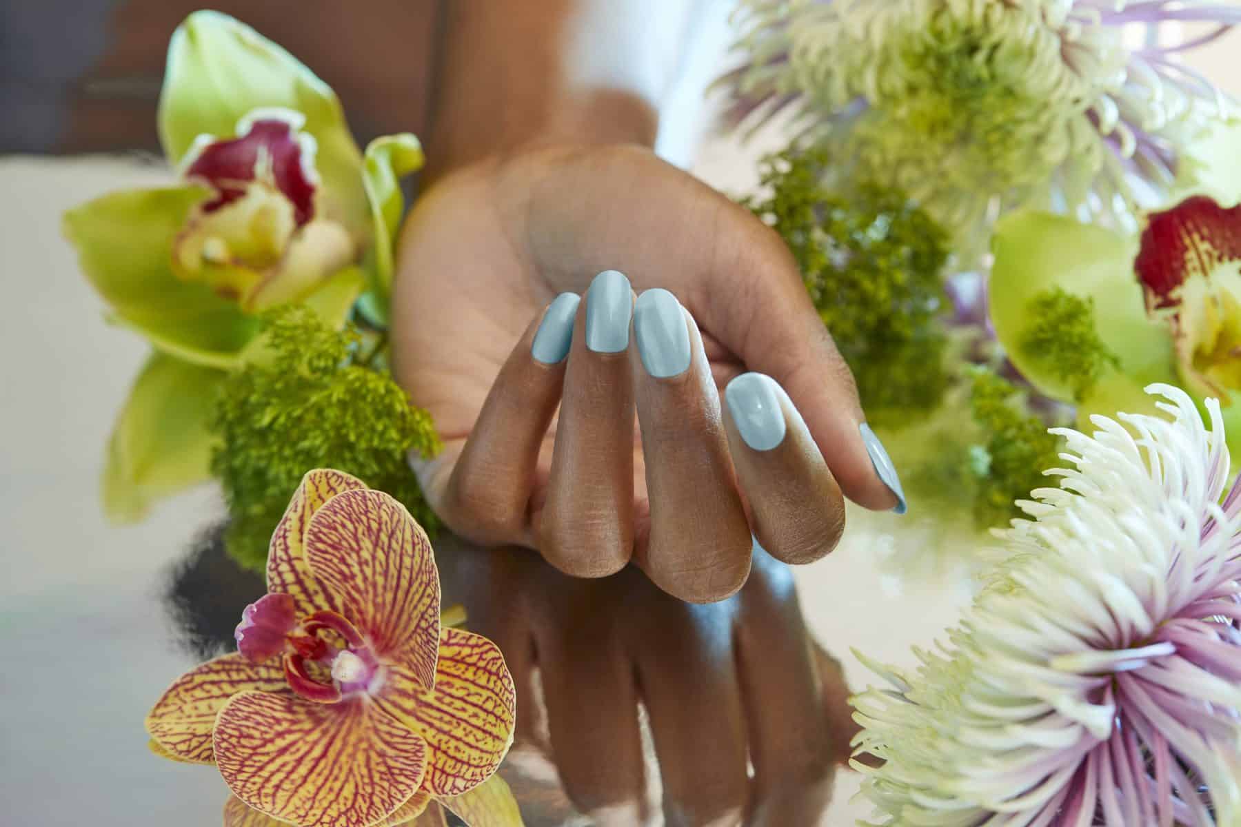 A hand with painted nails in the "Sage Simulation" shade from the Palette Xbox collection from OPI