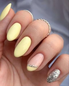 Pink and silver glitter nail art on a light yellow nail polish