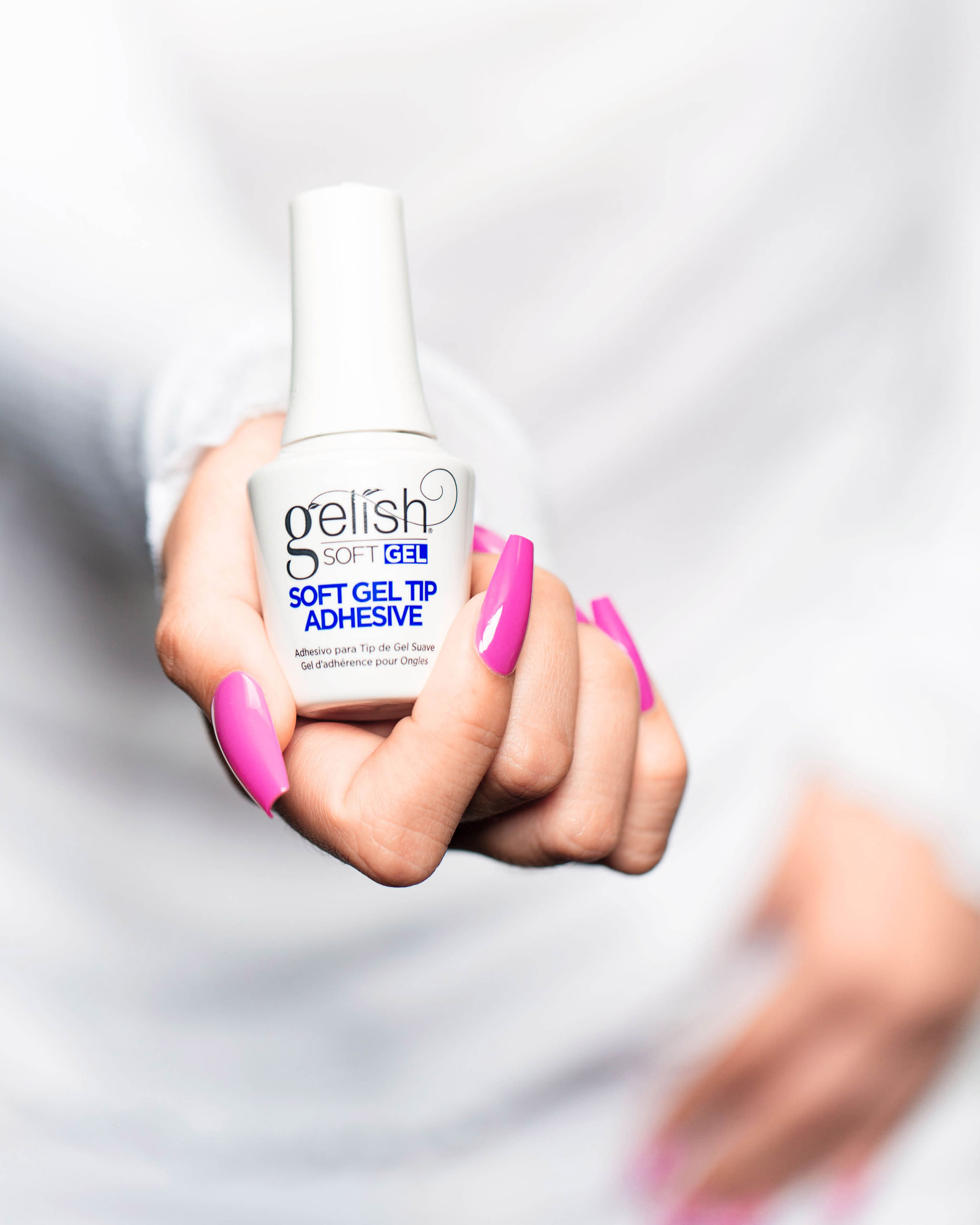 Soft Gel Adhesive Bottle and Pink manicure hand shot