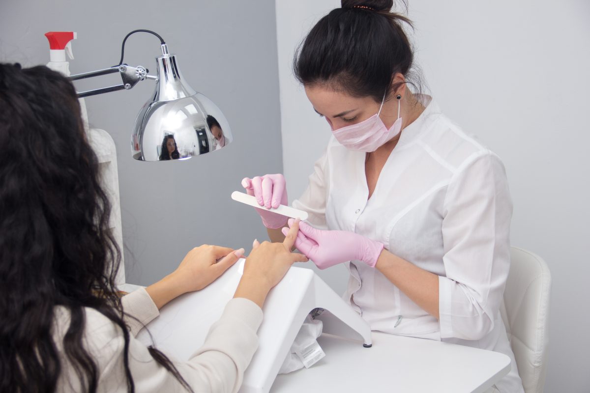 Portrait of a customer having a regular manicure session by an attractive nail salon worker. Healthy Nails