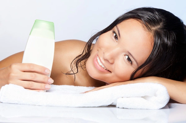 A lovely lady smiles while handing a hair shampoo