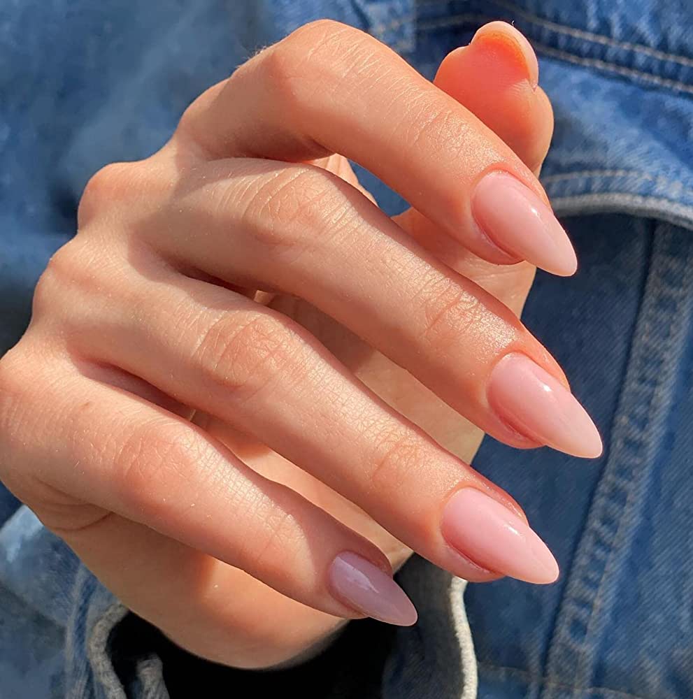A faceless woman's hand with polygel-type nail enhancements on her nails.