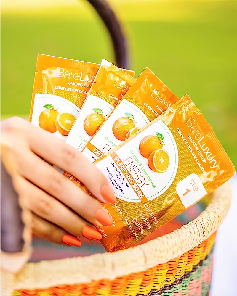 A woman's hand hold the four steps of the BareLuxury Energy Product, the Orange & Lemongrass fragrance