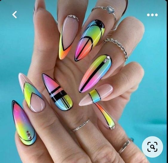 A woman's nails wearing silver rings with colorful geometric designs on them. Nail art trends