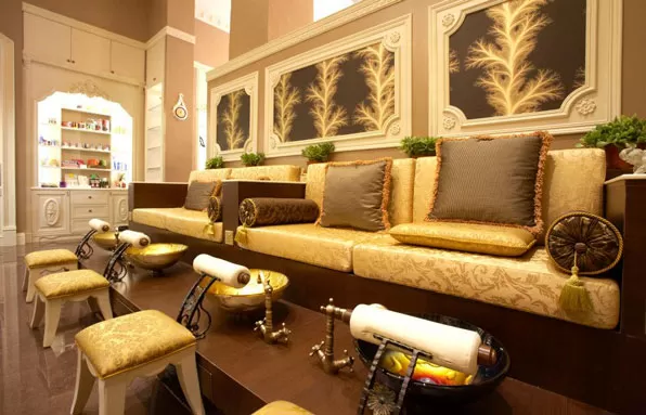 A nail salon with a vintage glam decoration theme, gold and brown furniture