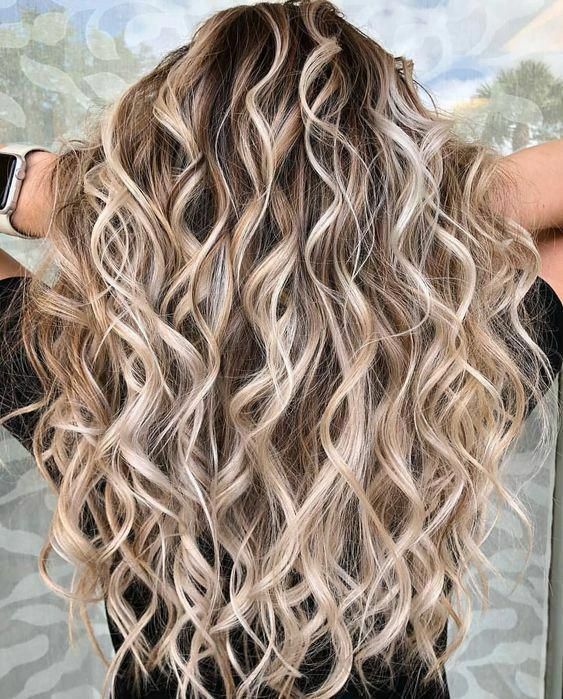 The back of a woman's head with long, wavy blonde hair.