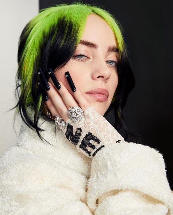 A close-up for Billie Eilish for her face and her long black painted nails