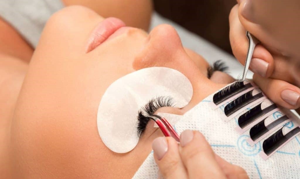 The application step for Ardell Lashes. Applying adhesive to lashes and then applying them to the client's eyes.