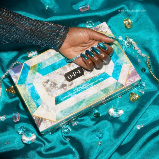 A faceless woman with wonderful long nails painted with the Tealing festive shade from the Jewel Be Bold collection from OPI for winter 2022