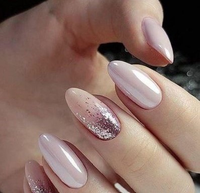 Female nail with beautiful holiday manicure - glittered nails