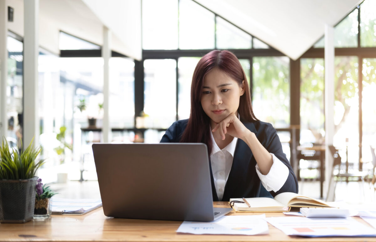 Asian woman working on laptop. Businesswoman busy working on laptop computer at the office putting the financial plan of a nail salon services.