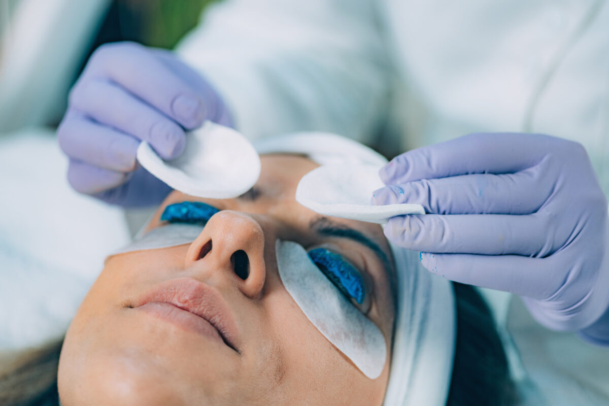Cosmetologist Puts BluePaint on the Eyelashes During Lash Lifting Procedure. Laminating Eyelashes.