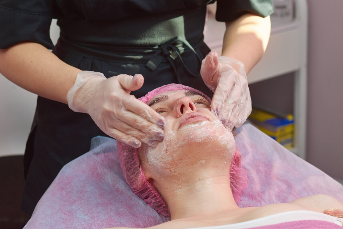 Face peeling in beauty clinic. Hands of cosmetician in gloves. Care routines for problematic skin.