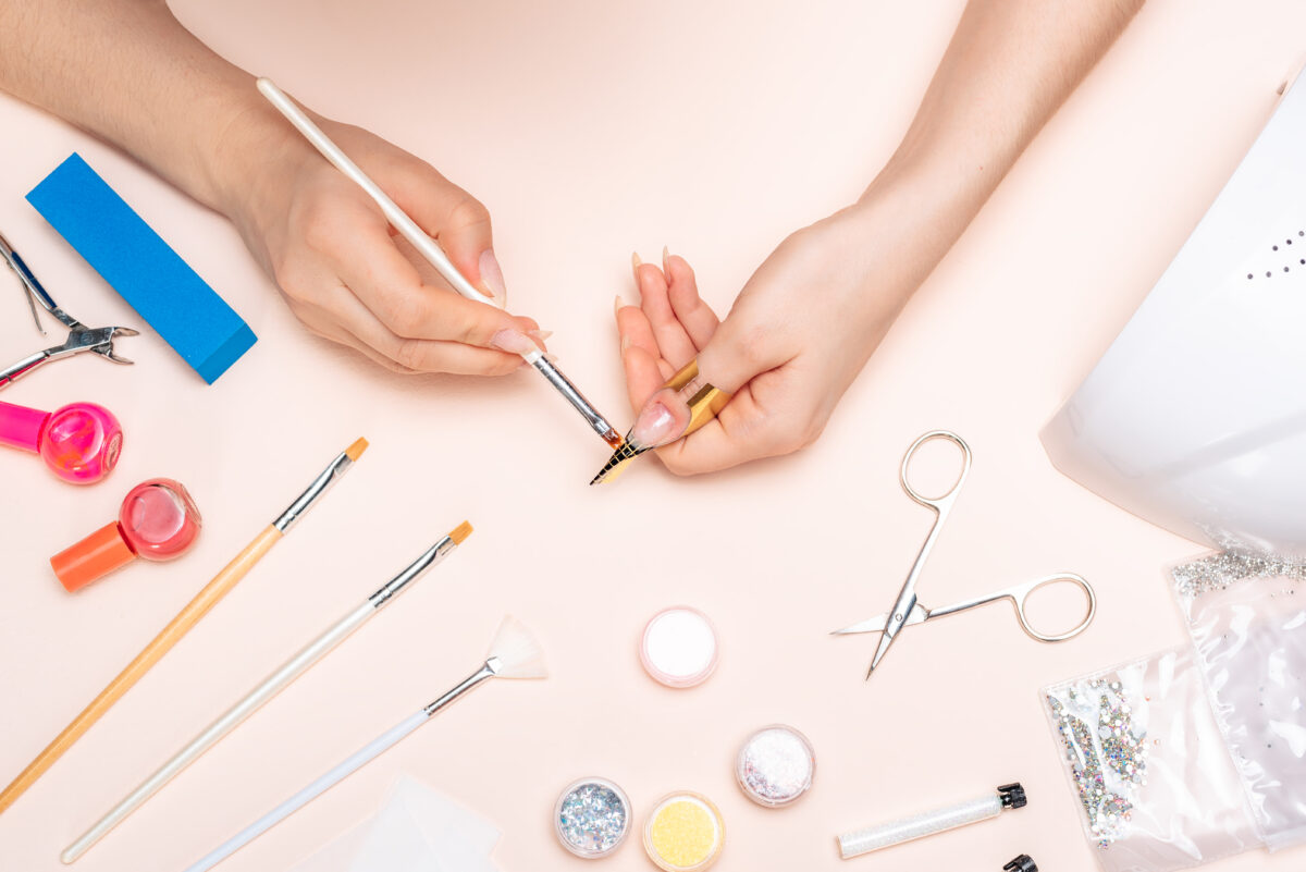 hands girl applying gel to her nails with a brush. the view from the top