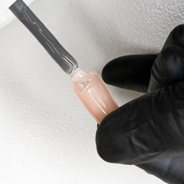 Fifth step of the applying technique for the Soft Gel Neutral Tips, apply the Gelish Soft Gel Tip Adhesive to the tips