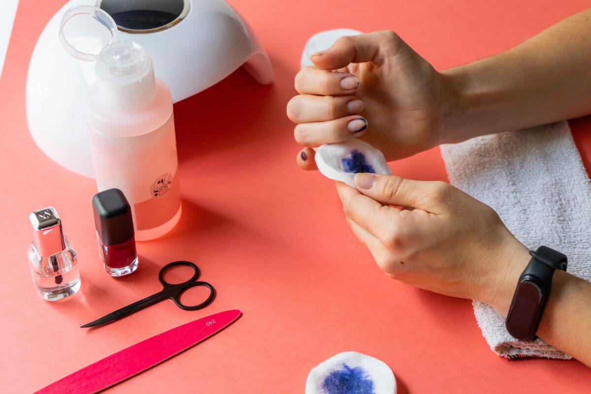 A young woman removing nail polish from her fingernails in a nail salon environment