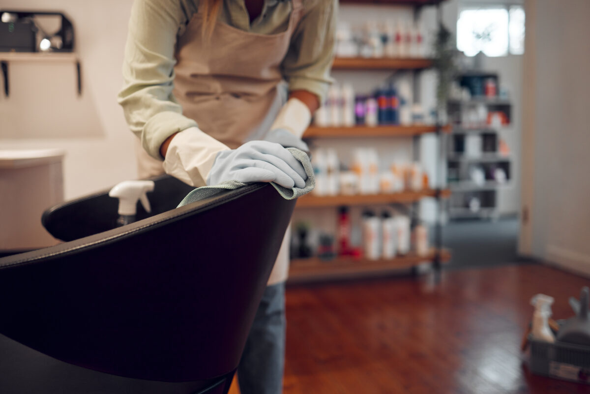 A woman cleaning the pedicure chair with equipment in a modern beauty parlour in a nail salon.
