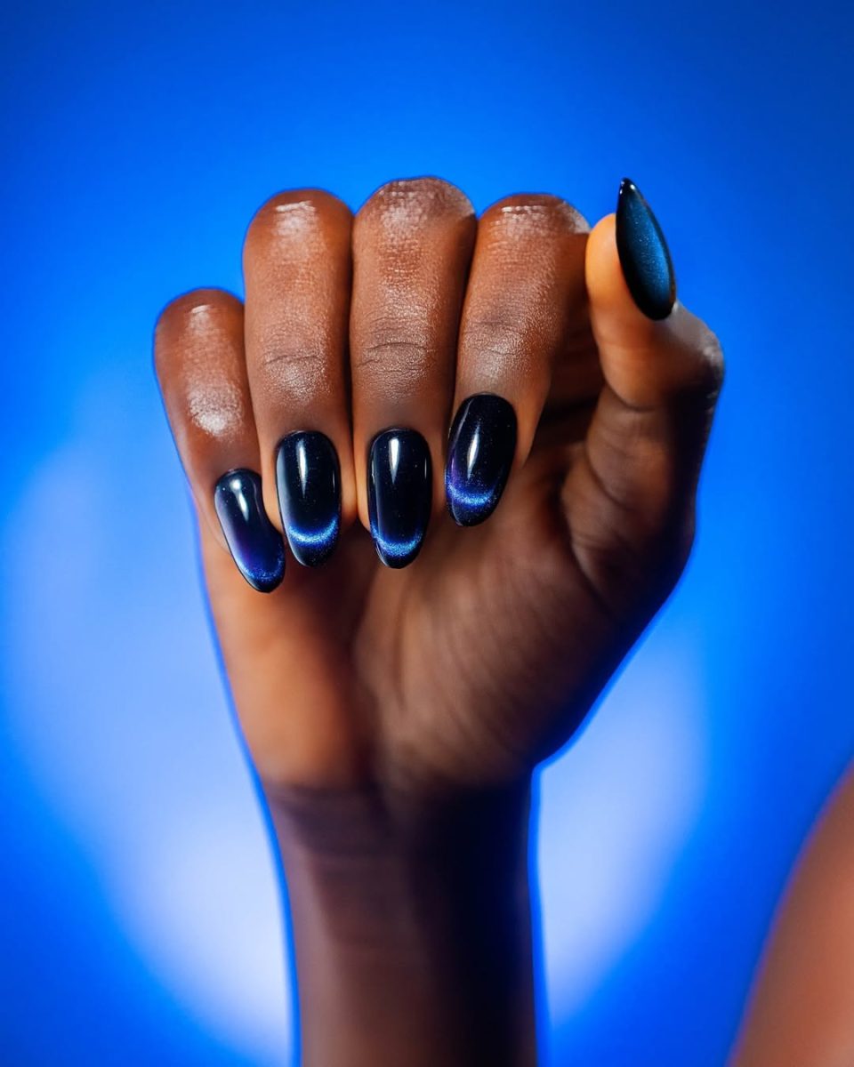faceless woman nails painted with magenta to blue gel polish from the Entity Halo Cat-Eye gel polish.