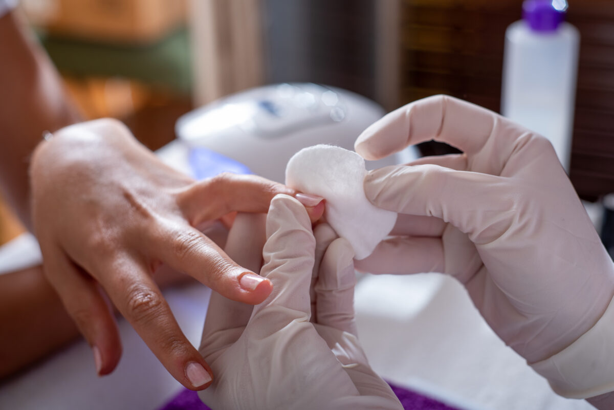 Shot of a beautician finishing manicure. removing nail polish. nail care.