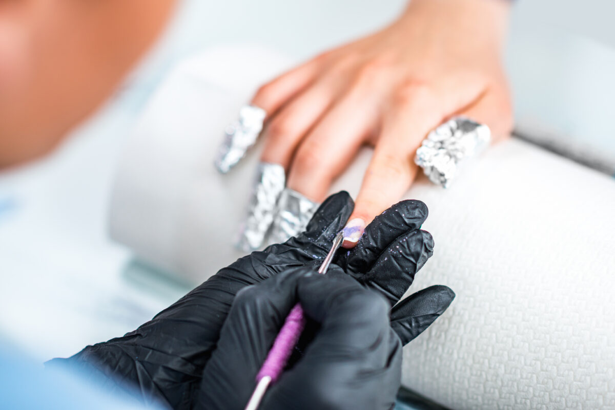 Soak off gel in beauty salon. Manicuring nails. removing gel polish