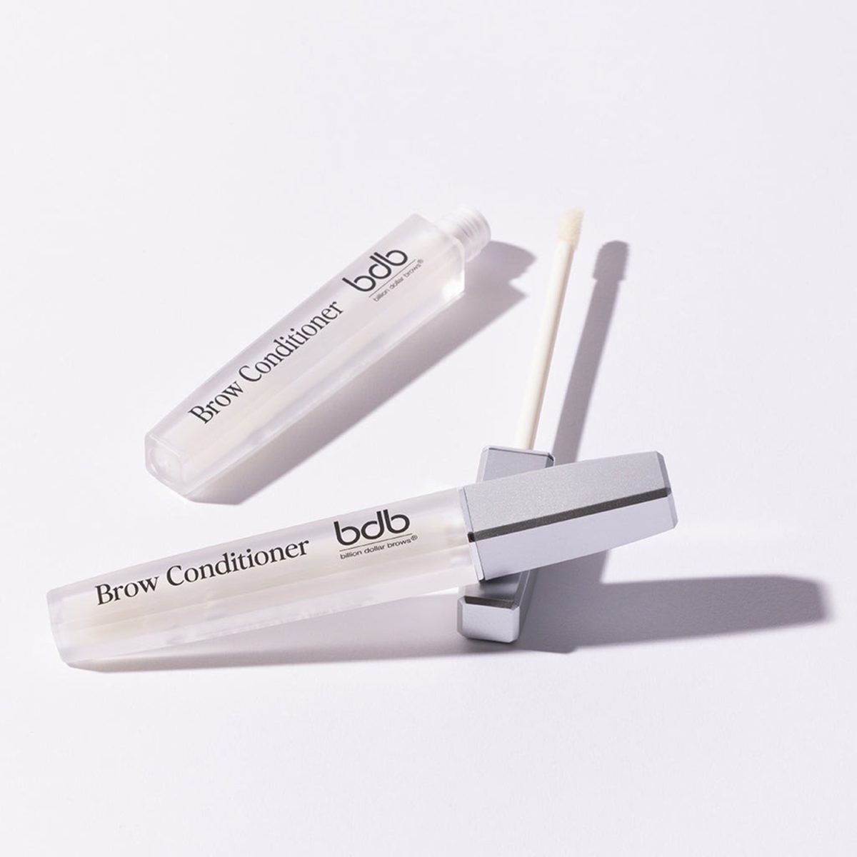 BDB Brow Conditioner bottles, display on a white wall. One of the Brow Conditioner are opened.