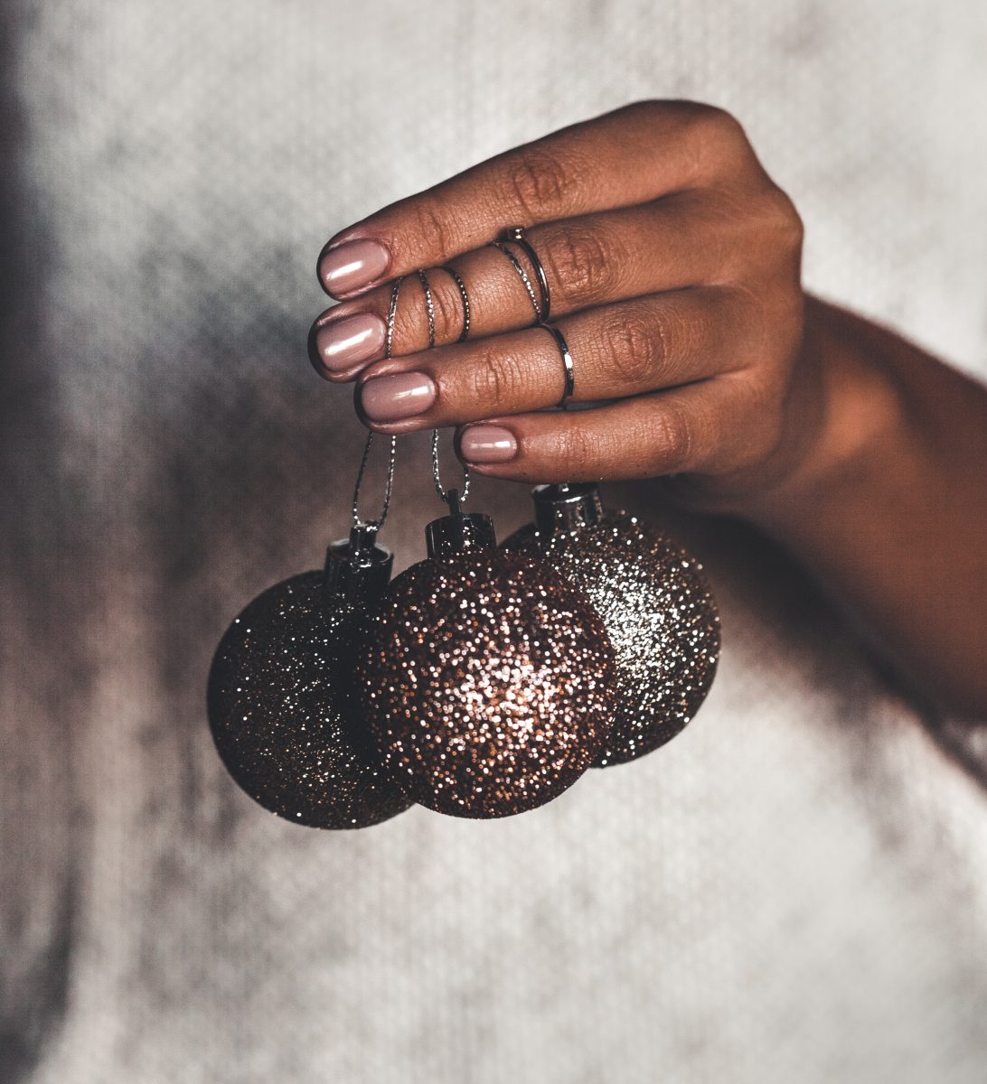 CND Winter 2024 nail polish collection. Holiday Manicure. Woman in warm sweater holding toys glass decorative balls in hands, copy space. Christmas, new year holiday celebration concept.