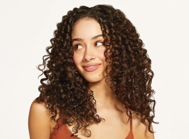A beautiful woman with curly bold brown long hair.