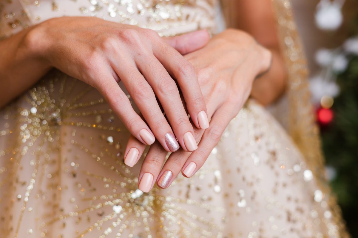 Female hands with Christmas new year nail design. Nude beige nail polish manicure. Oscar 2024 event. Met Gala 2024 event