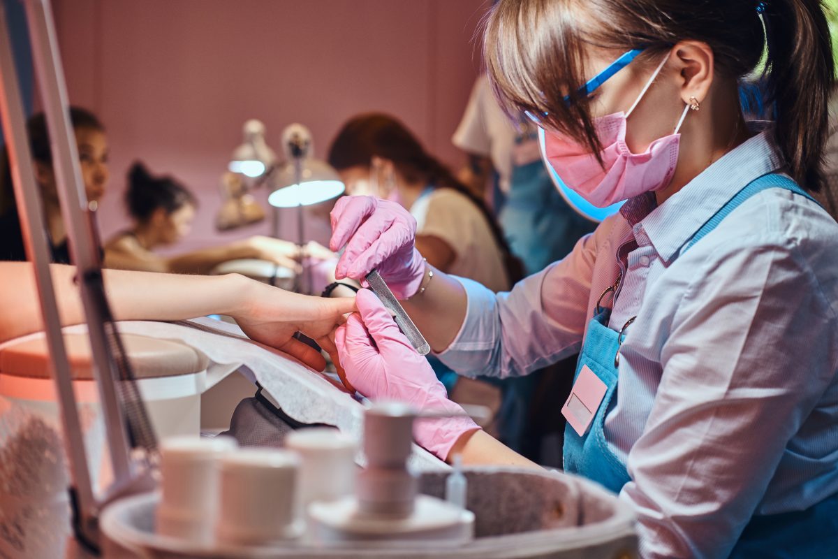 Freelance or salon work. Nail treatment process at manicure studio. Customer is receiving good service from experienced master.