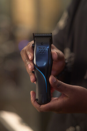 A faceless Black man holds the Wahl Professional 5-Star Vapor Clipper, which features the industry's first adjustable balding blade, the new F32 Fadeout Blade.