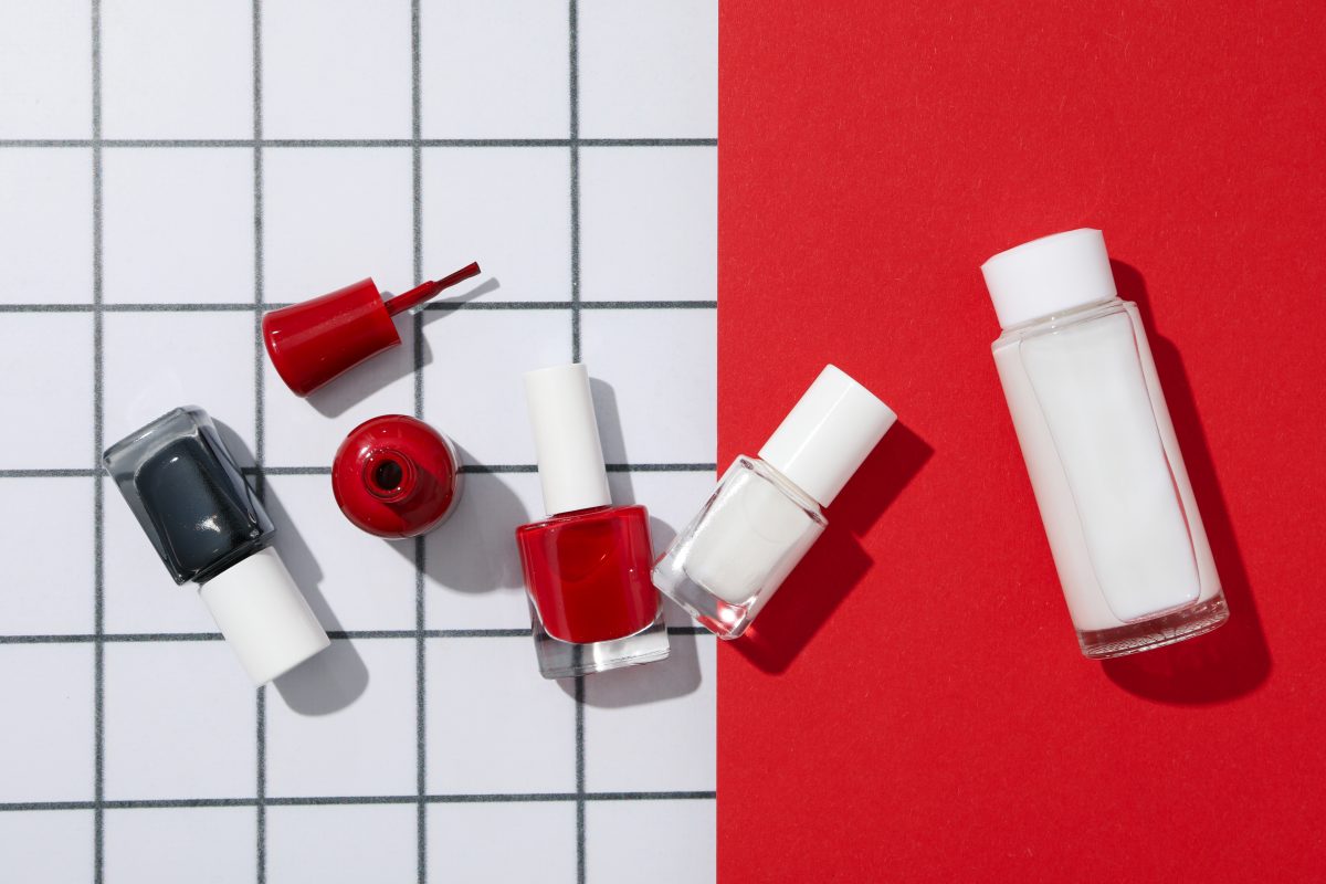 Multicolored nail polishes on a red and white background. nail polishes. nail lacquers.
