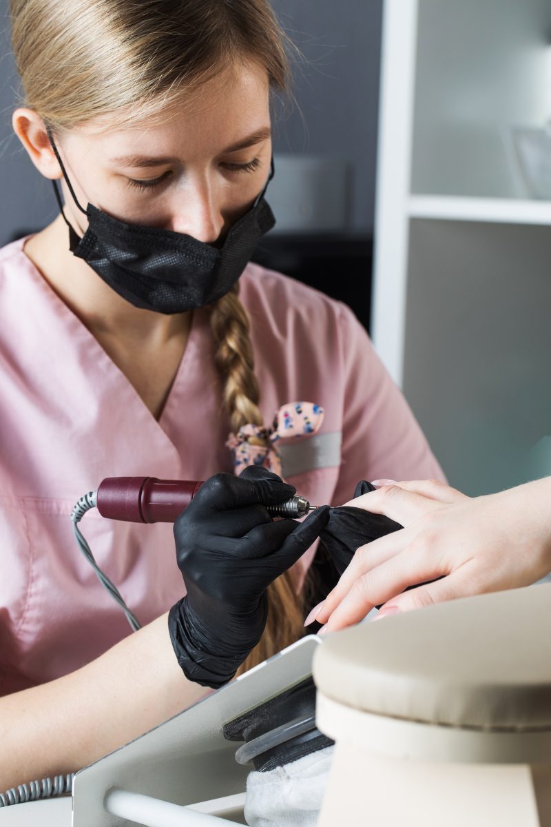 Hardware manicure. Manicure process, cuticle removal with a cutter. Processing nails with an electric file. High quality photo. nail drill. e-file for nails. Portable Nail Drills.
