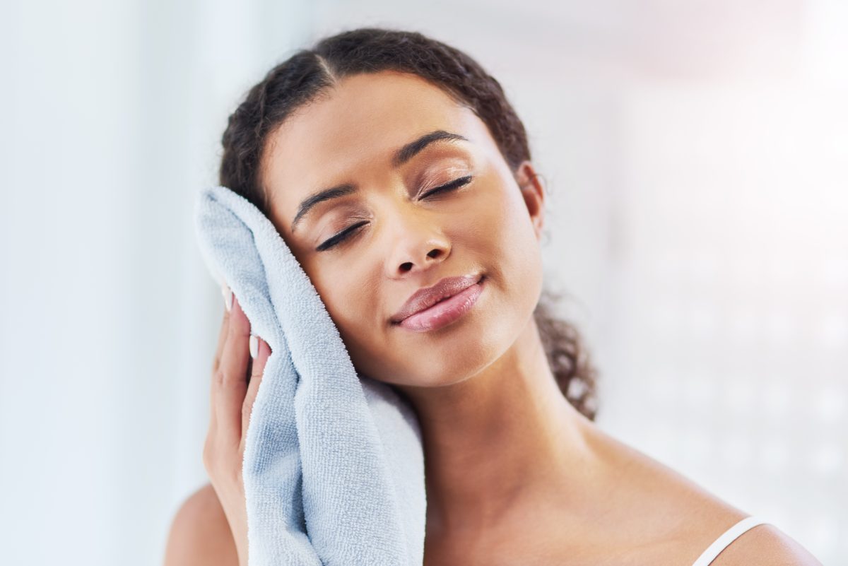 Cropped shot of a young woman drying her face in the bathroom at home. Salon & Spa Towels. Facial Towels