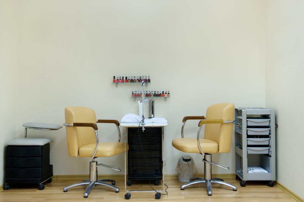 place for a manicure in a beauty salon in bright colors. Two chairs and a table in the nail care room. Nail Technician Chair + Customer Chair
