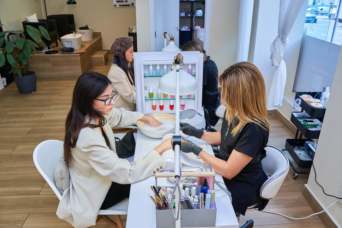 Young girls use the service of Express manicure in the salon of the shopping center. Proper Way to Sit for Long Hours.