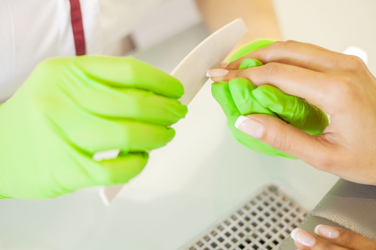SPA manicure. French manicure at spa salon. Woman hands in a nail salon receiving a manicure procedure.