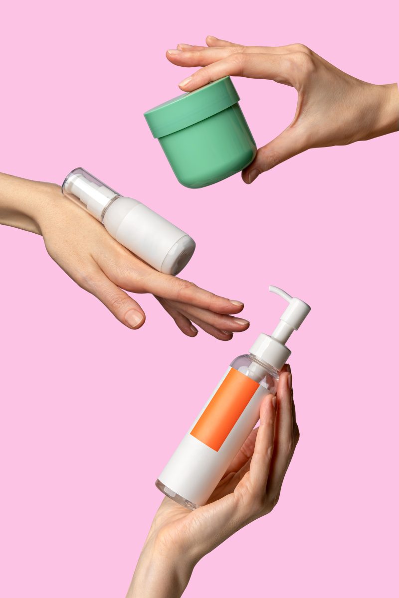 Woman`s hands showing set of cream products. Cosmetic product branding mockup. Daily skincare and body care routine. Female hand holding  cosmetic product mockup on a light pink background. Close up. What Are Sulfates and Why Are They in Shampoos? hair care. hair treatment.