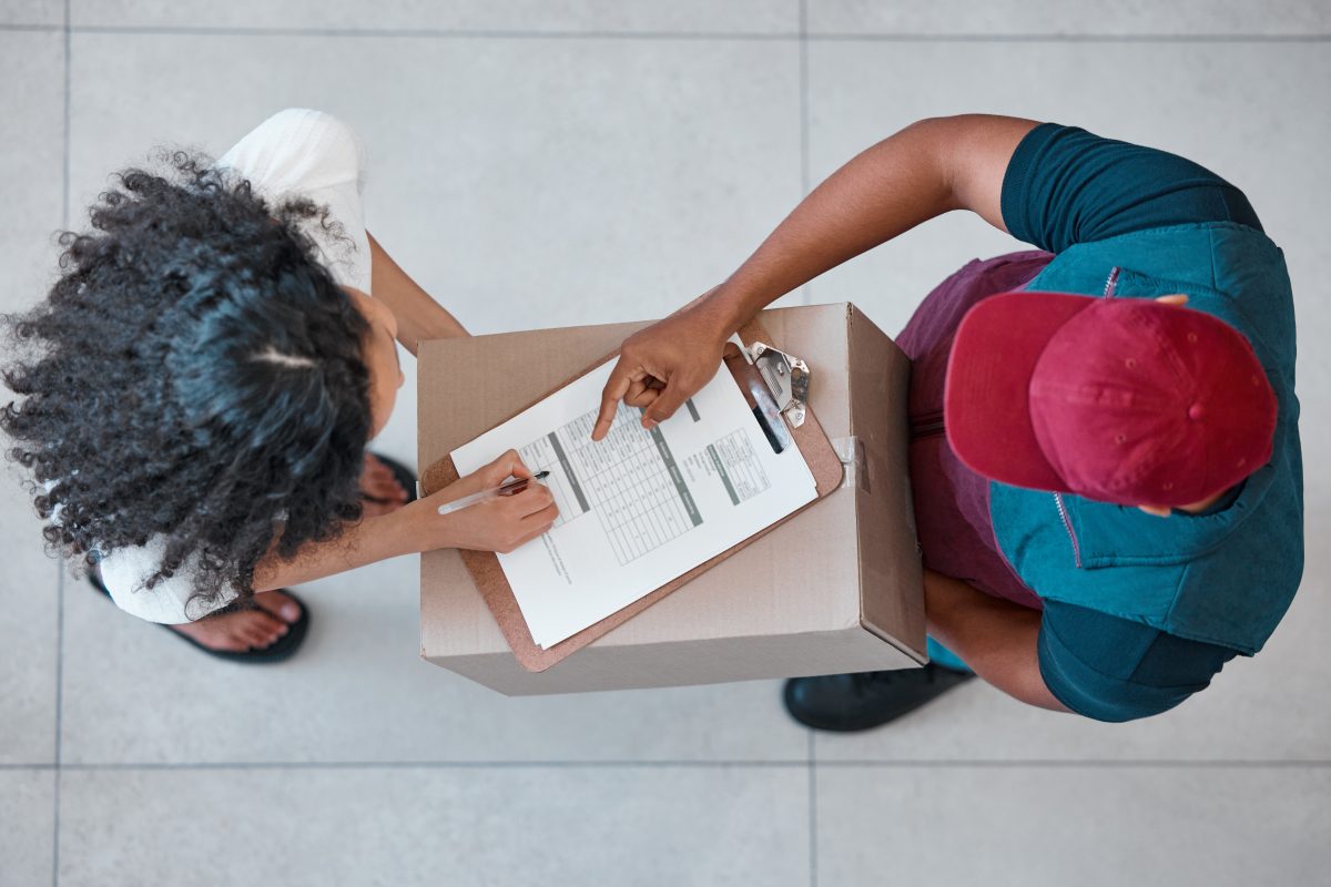 Delivery, shipping and logistics with a woman customer and man courier signing documents from above.