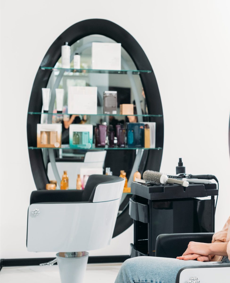 happy hairdresser and customer looking at new hairstyle