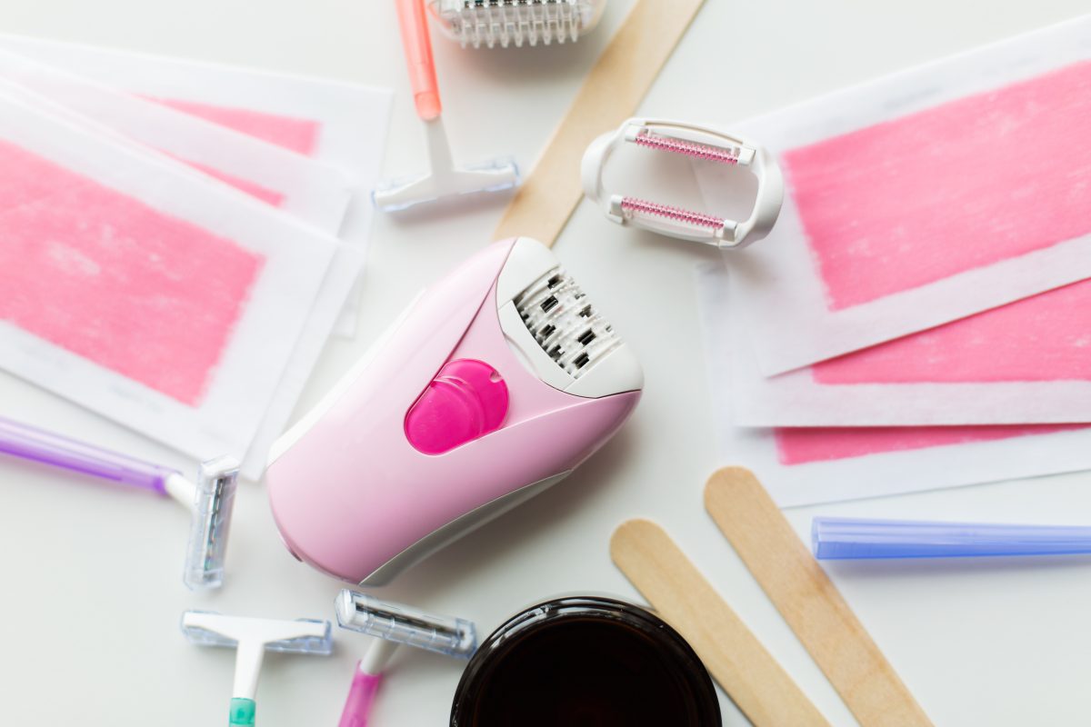 beauty, depilation and hair removal concept - wax with spatula, epilator and safety razor on white background