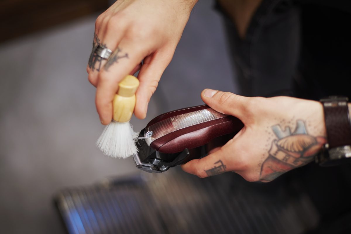 Man cleaning electric razor with shaving brush