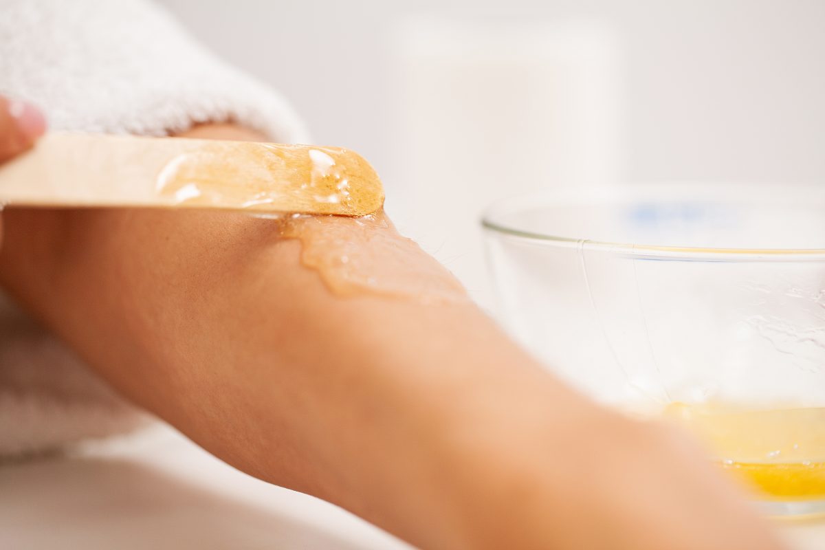 Skin care, a woman applies wax to her hand to remove hair.