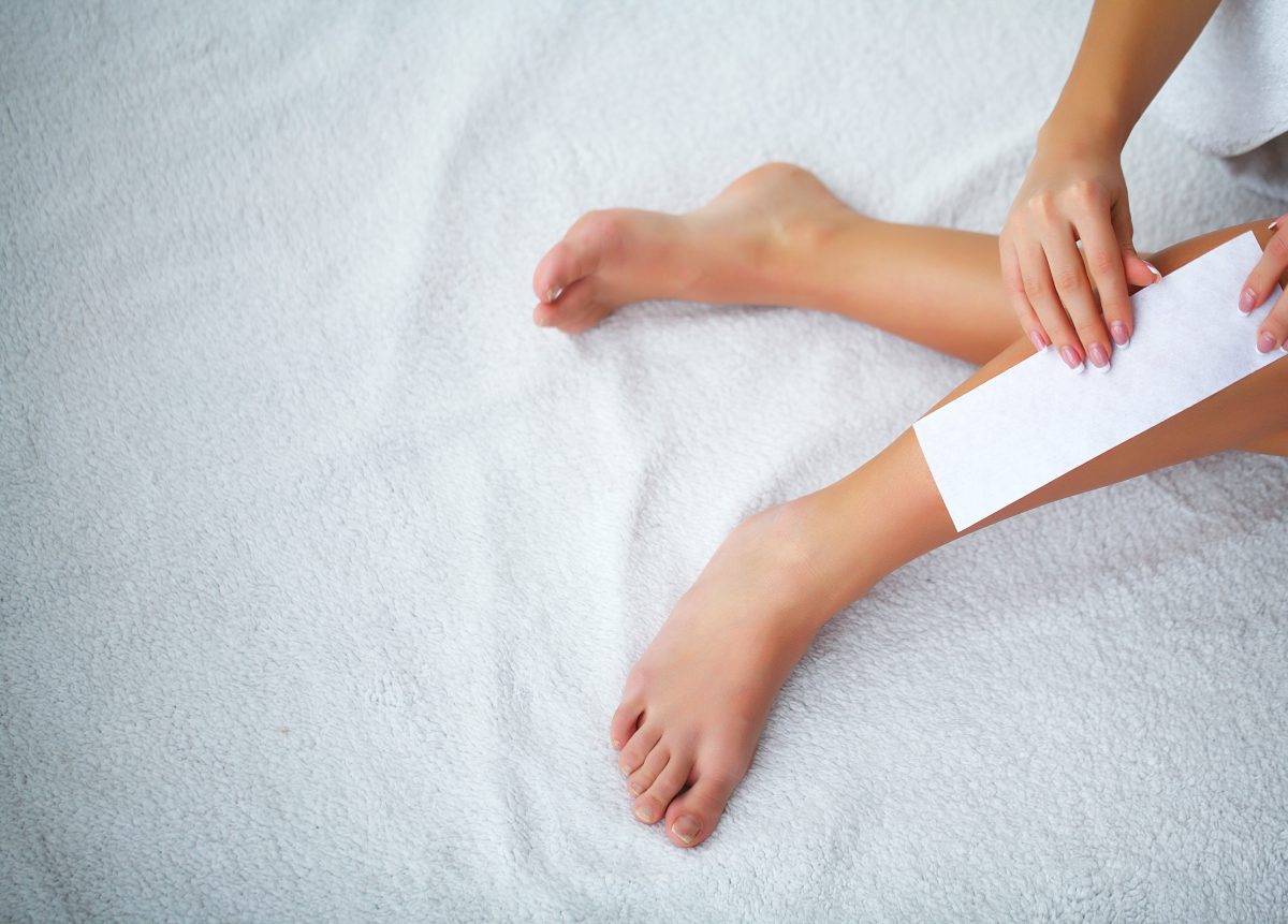 Waxing. Depilation legs with waxing and tape