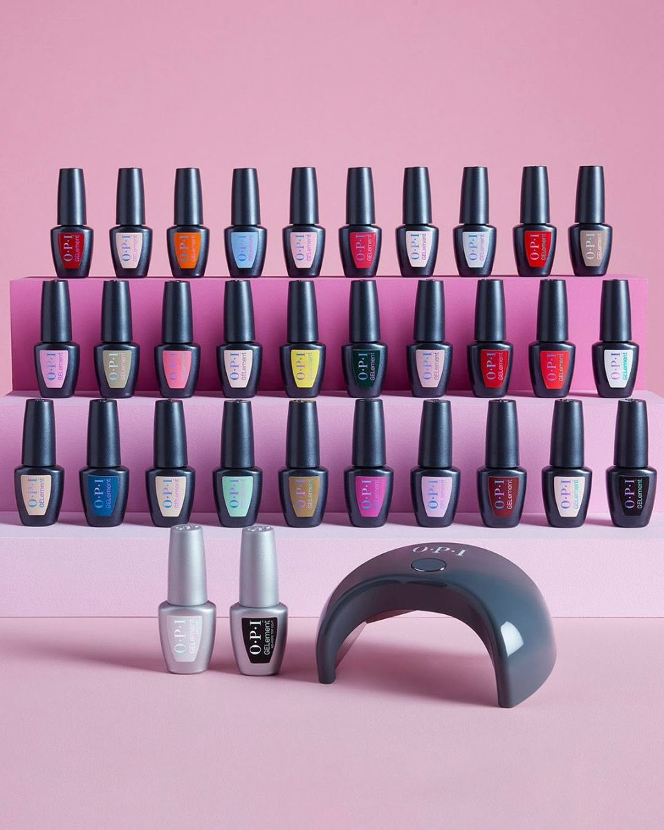 Tiered display of 30 OPI GELement gel polish bottles in vibrant crème and shimmer shades, arranged beside a sleek black LED lamp—highlighting the full at-home gel manicure system.