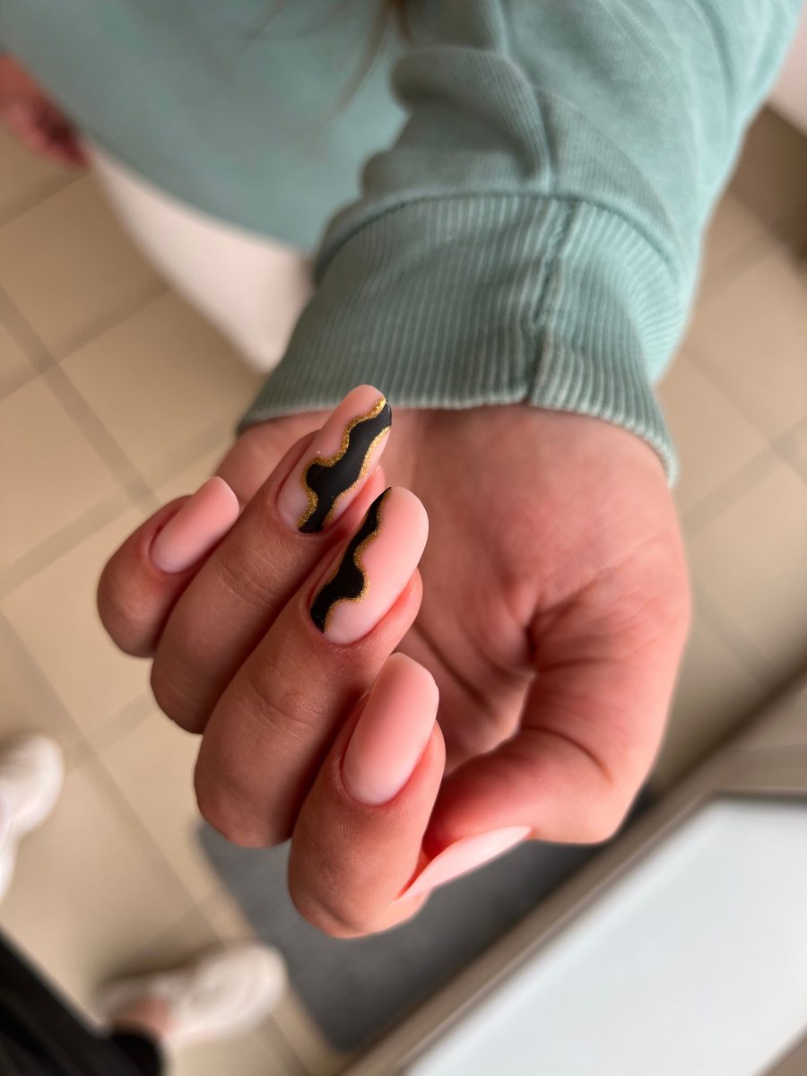 A closeup image of a female hand with professionally painted nails in natural tones. Spring nails. Spring 2025 nails.