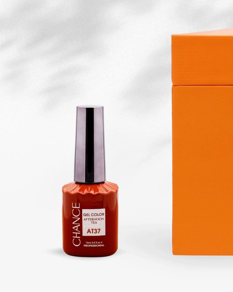 A close-up shot of a single 15ml Chance Gel Color Afternoon Tea bottle, featuring shade code AT37. The bottle is a deep terracotta or rusty red color, standing next to the closed orange collection box. The focus is on the polish label and the silver-chrome cap. Chance Creation Collections