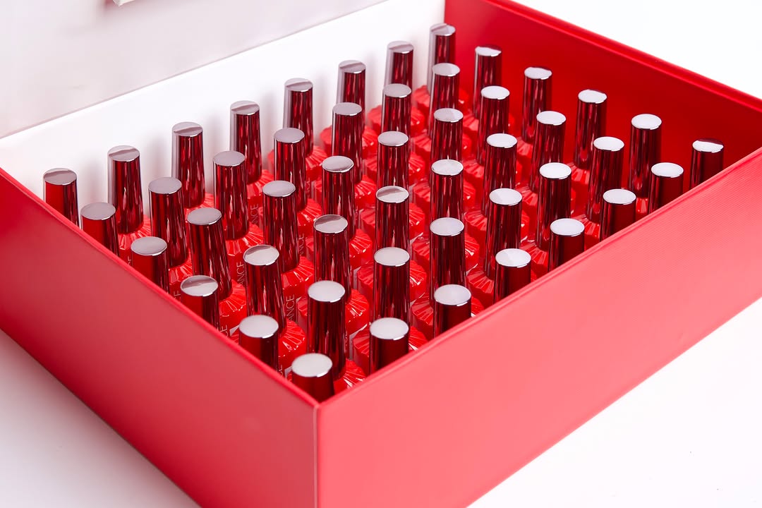 Overhead view of the open Chance "London Red" Full Kit showcasing all 48 gel polish bottles arranged neatly inside the red collection box. The red glass bottles with bright silver-chrome caps create a striking, uniform pattern, representing a complete professional red gel color inventory for nail salons.