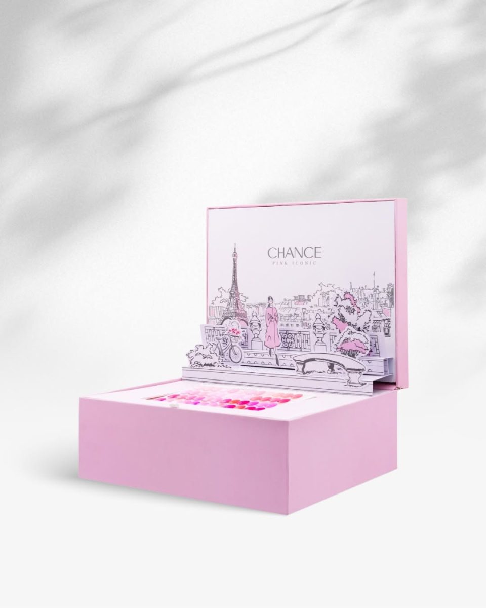 Overhead, close-up flat lay of the Chance "Pink Iconic" Full Kit packaging. The image shows the corner of the open display, revealing the 48-shade pink swatch board, framed by three corners of other closed pink collection boxes. The visible text on the lower box reads "CHANCE PINK ICONIC," highlighting the professional product packaging. Chance Creation Collections,