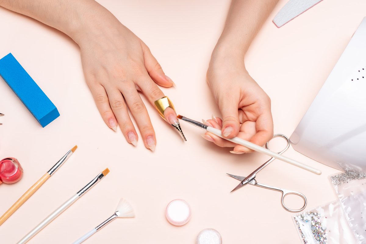 girl doing manicure at home, hands close-up. the view from the top. Length & Nail Bed Width